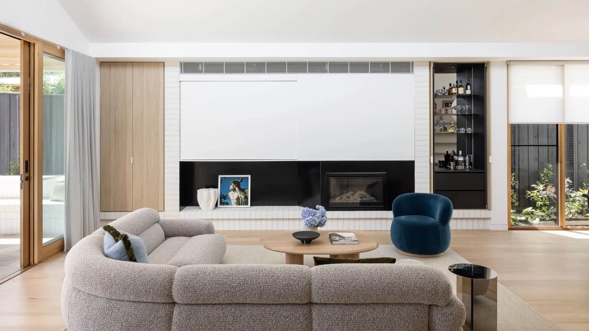 Modern living room featuring a FURNISHD couch and a cozy fireplace, creating a warm and inviting atmosphere.