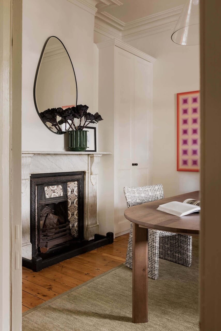 A cozy room featuring a FURNISHD fireplace, a table, and chairs arranged for comfortable seating.