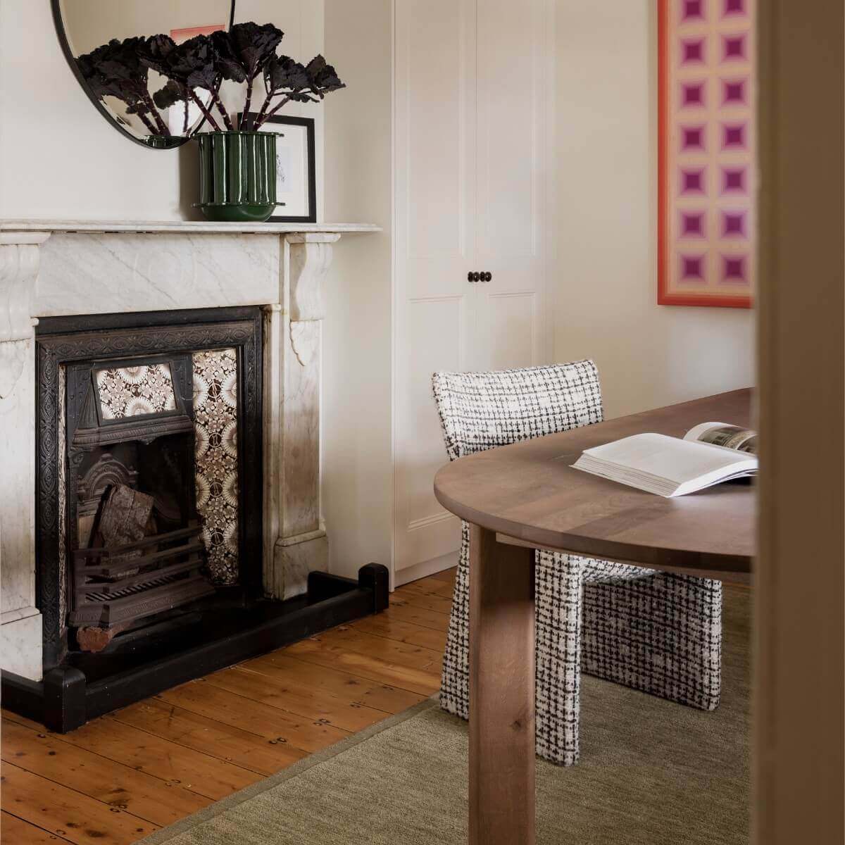 A cozy room featuring a FURNISHD fireplace, a table, and chairs arranged for comfortable seating.